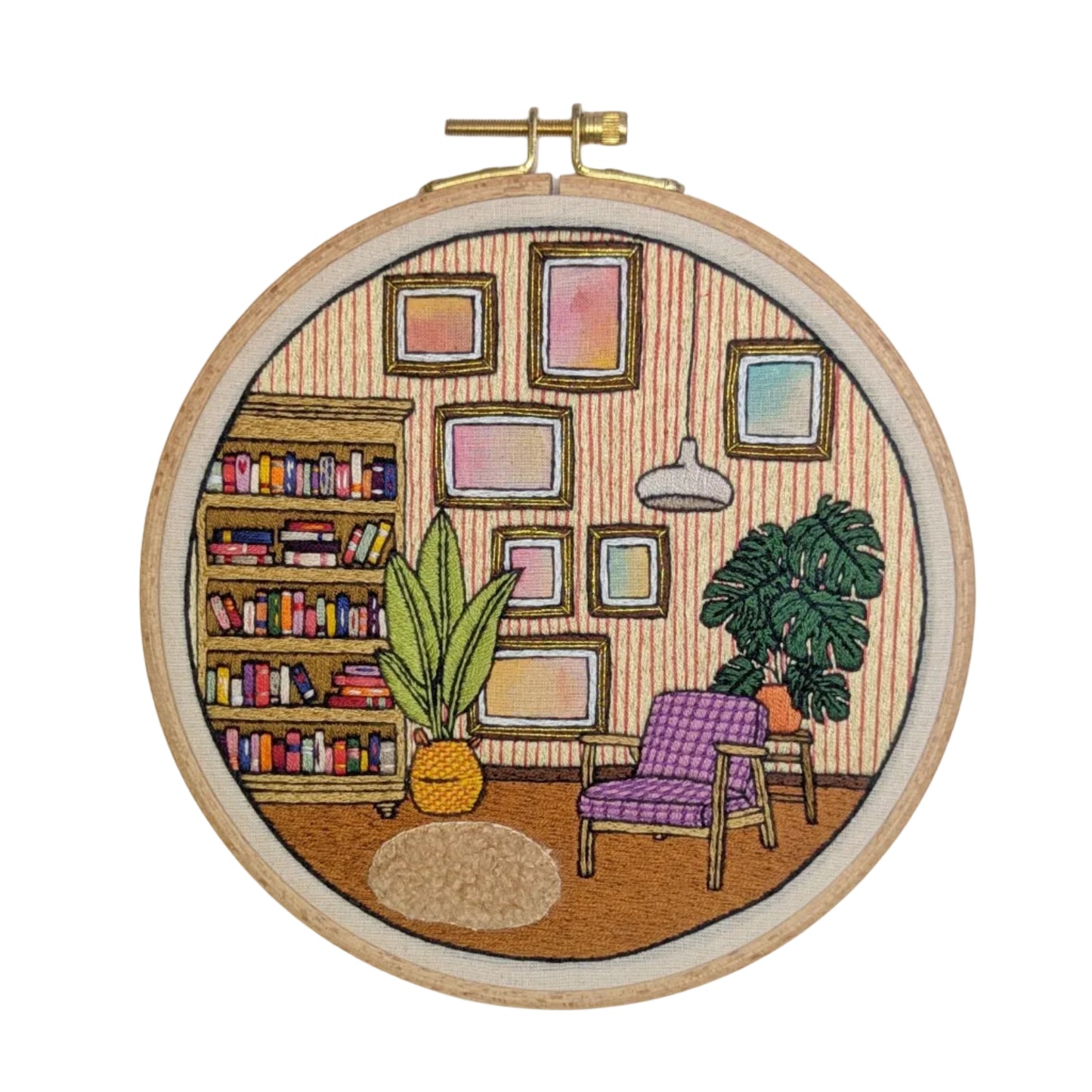 Embroidery hoop with a colorful depiction of a living room scene.