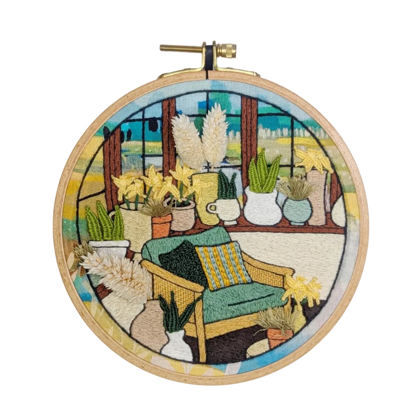 Embroidery hoop with a colorful scene of a  conservatory with plants and furniture.