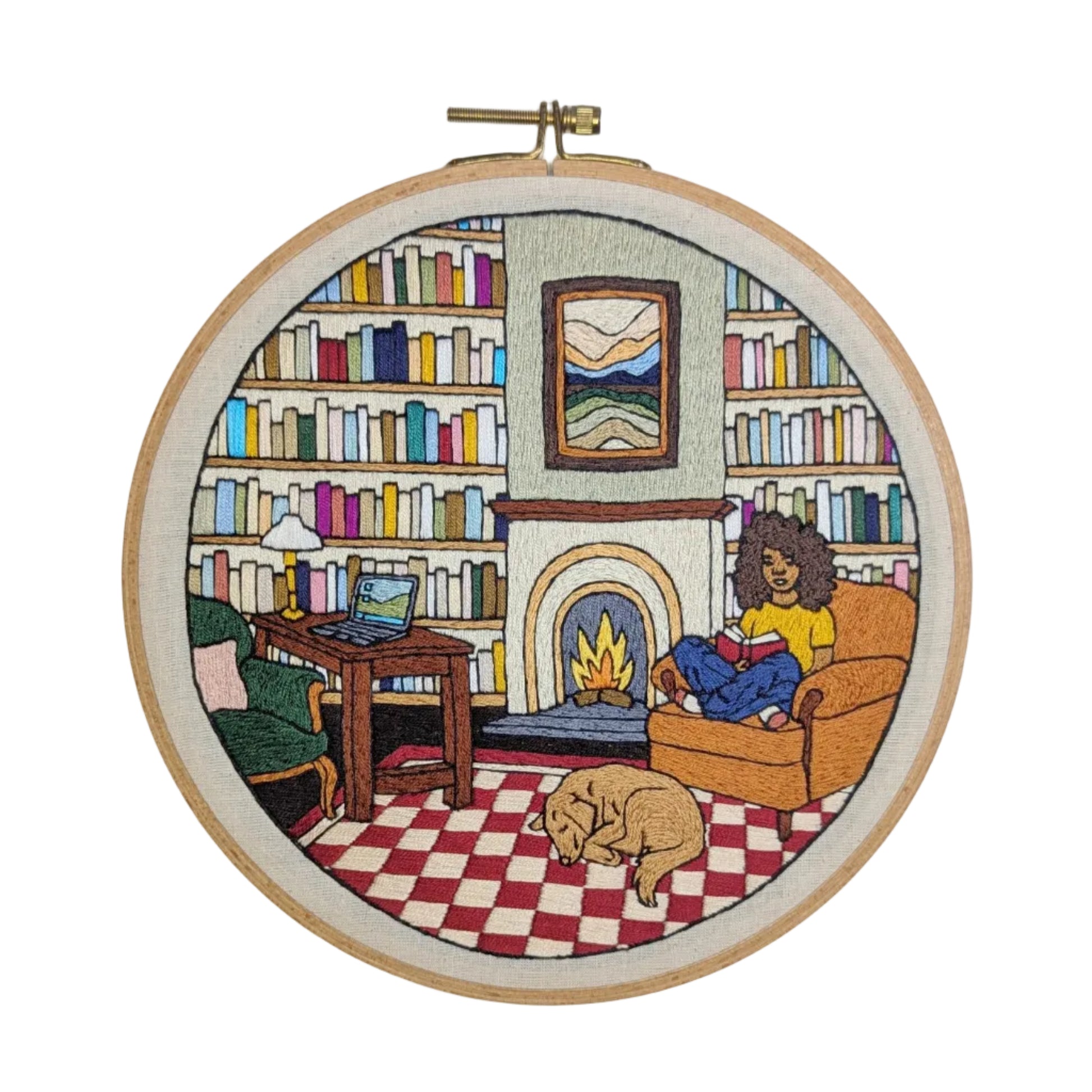 Embroidery hoop with a colorful depiction of a cozy living room scene.