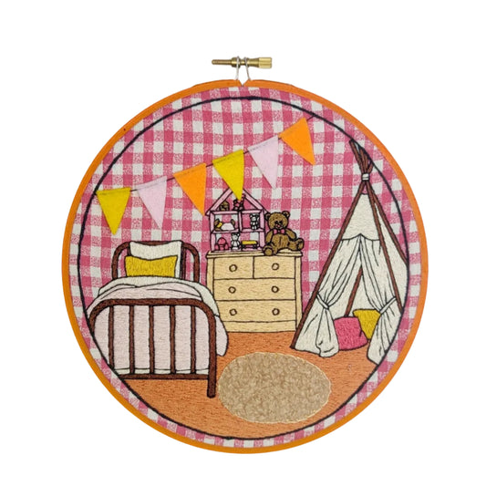 Embroidery hoop with a children's room scene on a pink checkered background